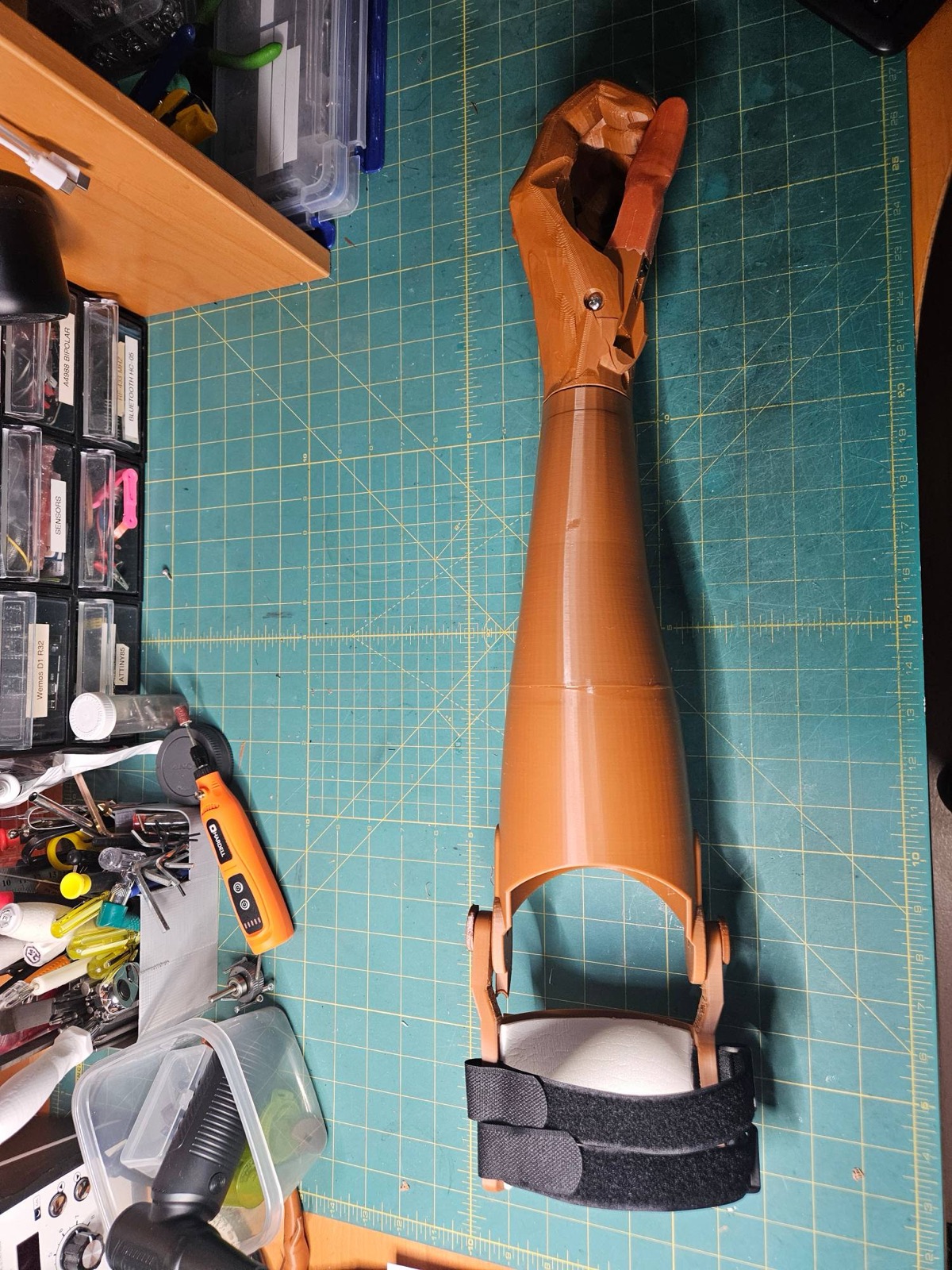 A full-length printed arm with a closed grip on a cutting mat